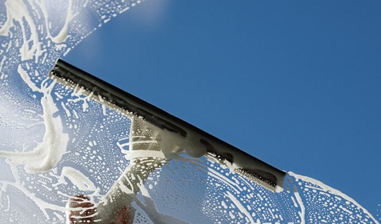 Nettoyer ses vitres sans traces avec une raclette